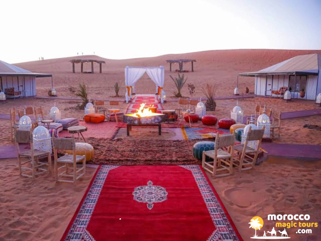 A luxury Sahara desert camp with a central bonfire prepared for guests during a 3 days tour from fes to marrakech