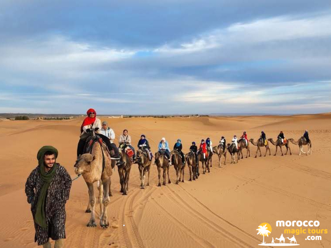 A local guide leading a camel trekking group over sand dunes on a 3 days tour from fes to marrakech