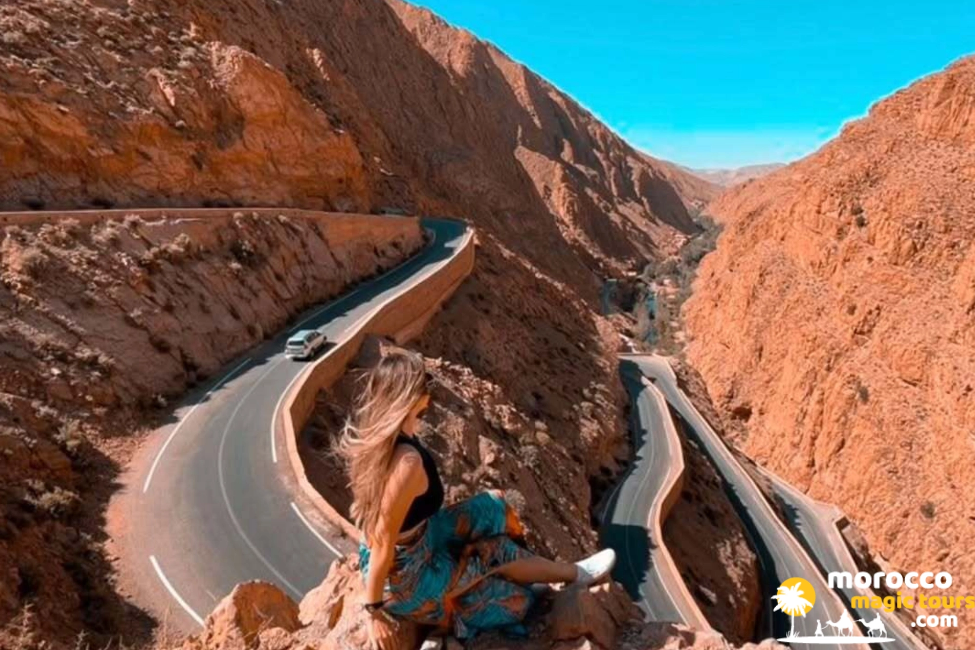 Tourist overlooking the famous winding hairpin road of Dades Gorge on a 6 days Sahara desert tour from Tangier