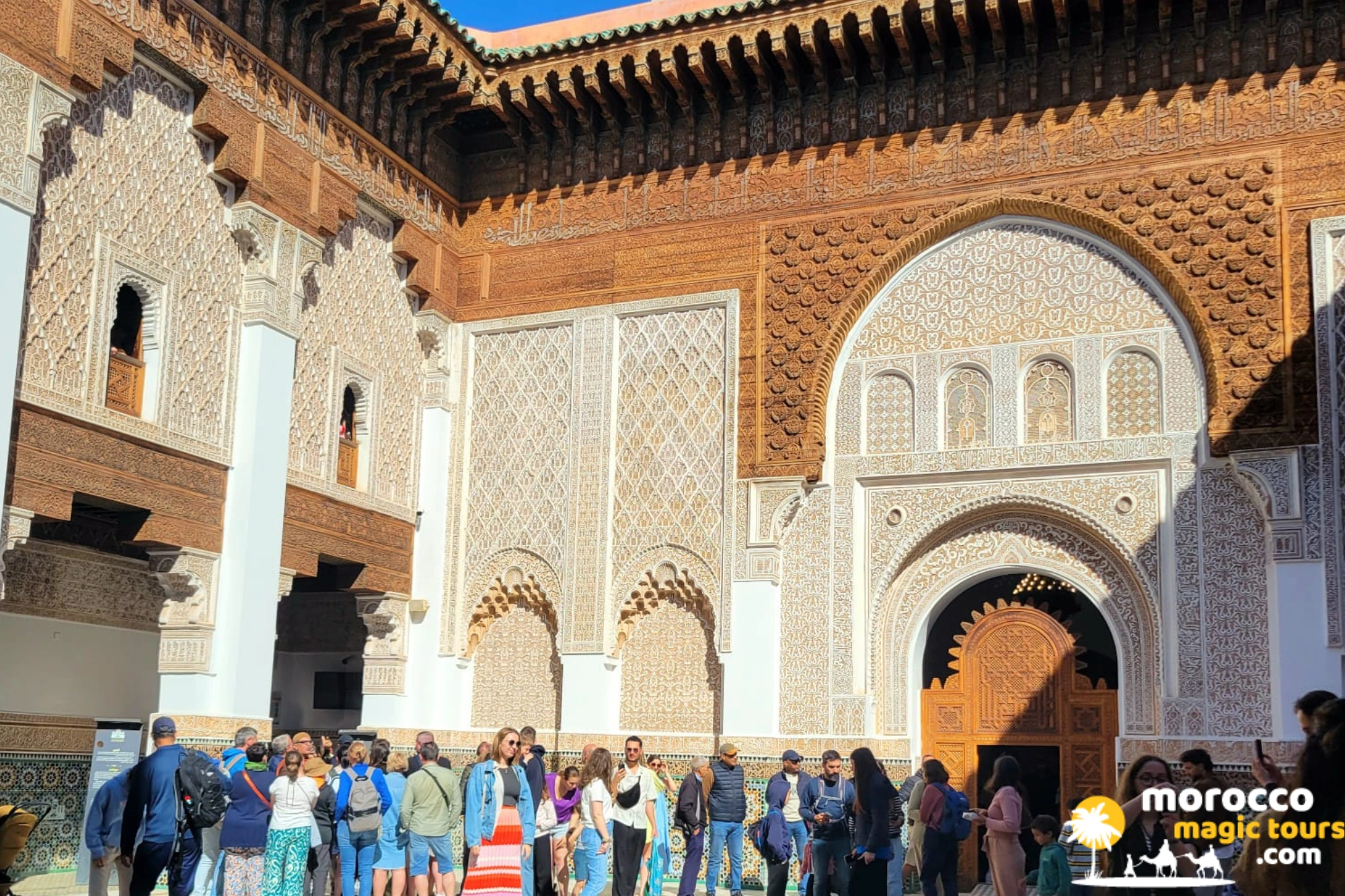 Intricate carved wood and zellij tilework inside Bou Inania Madrasa in Fes Medina on a 6 days Sahara desert tour from Tangier