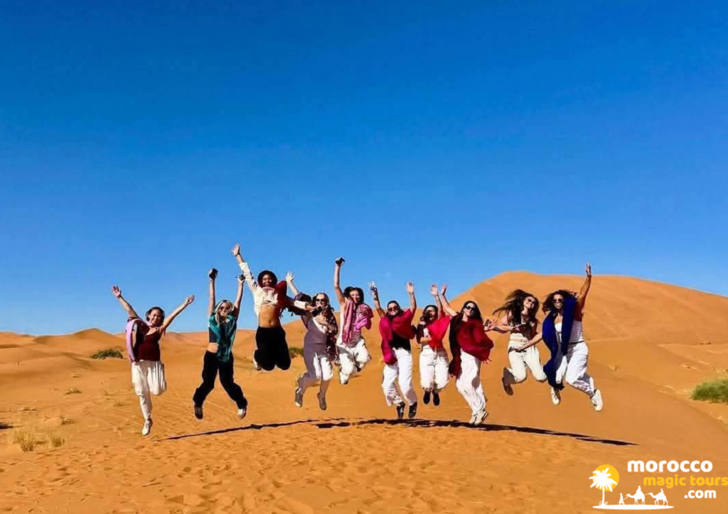 Group jumping on Sahara dunes during an 8 days in Morocco itinerary
