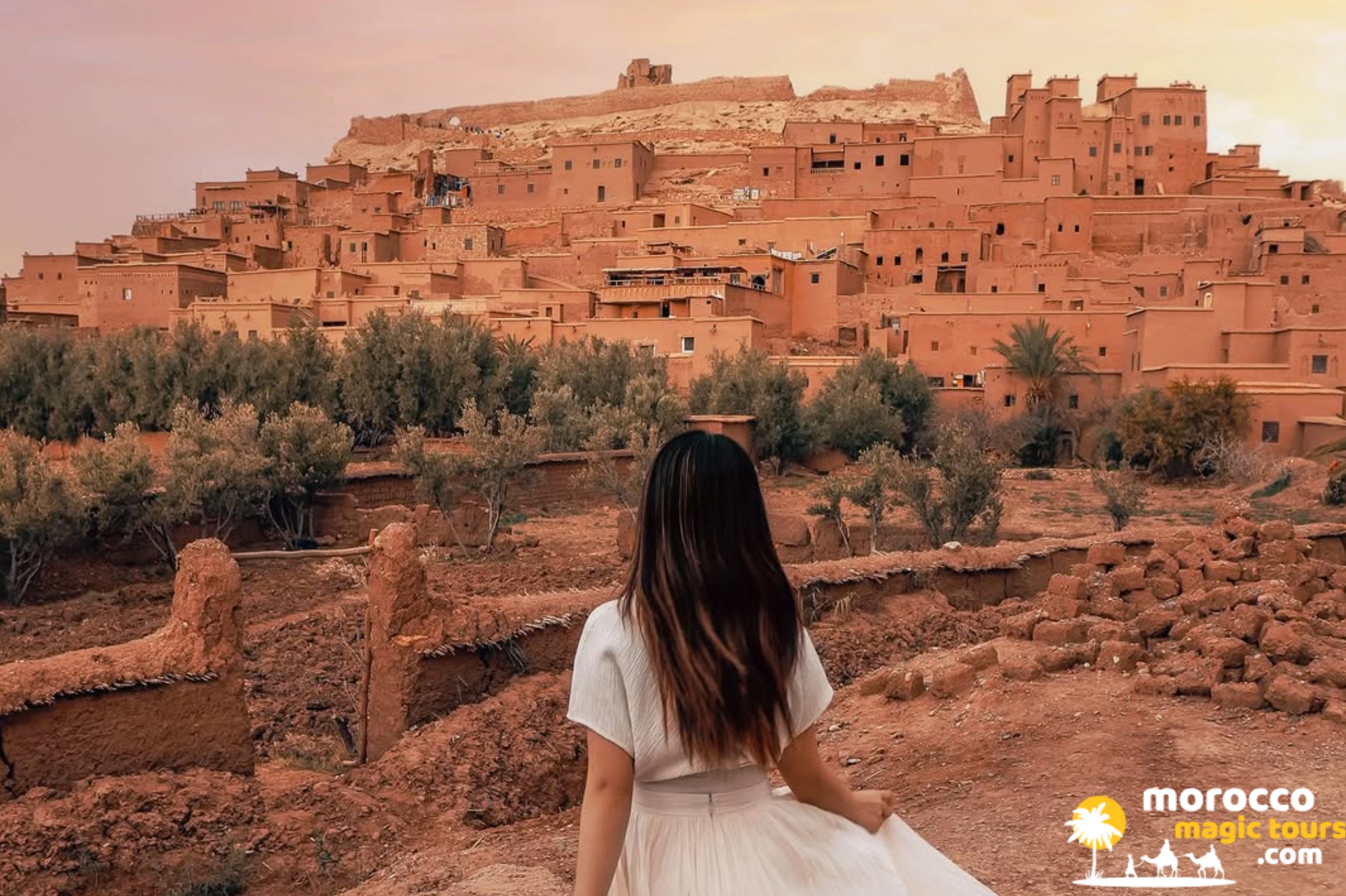 Traveler looking out at the historic mud-brick ksar of Ait Ben Haddou on a desert tour from Tangier