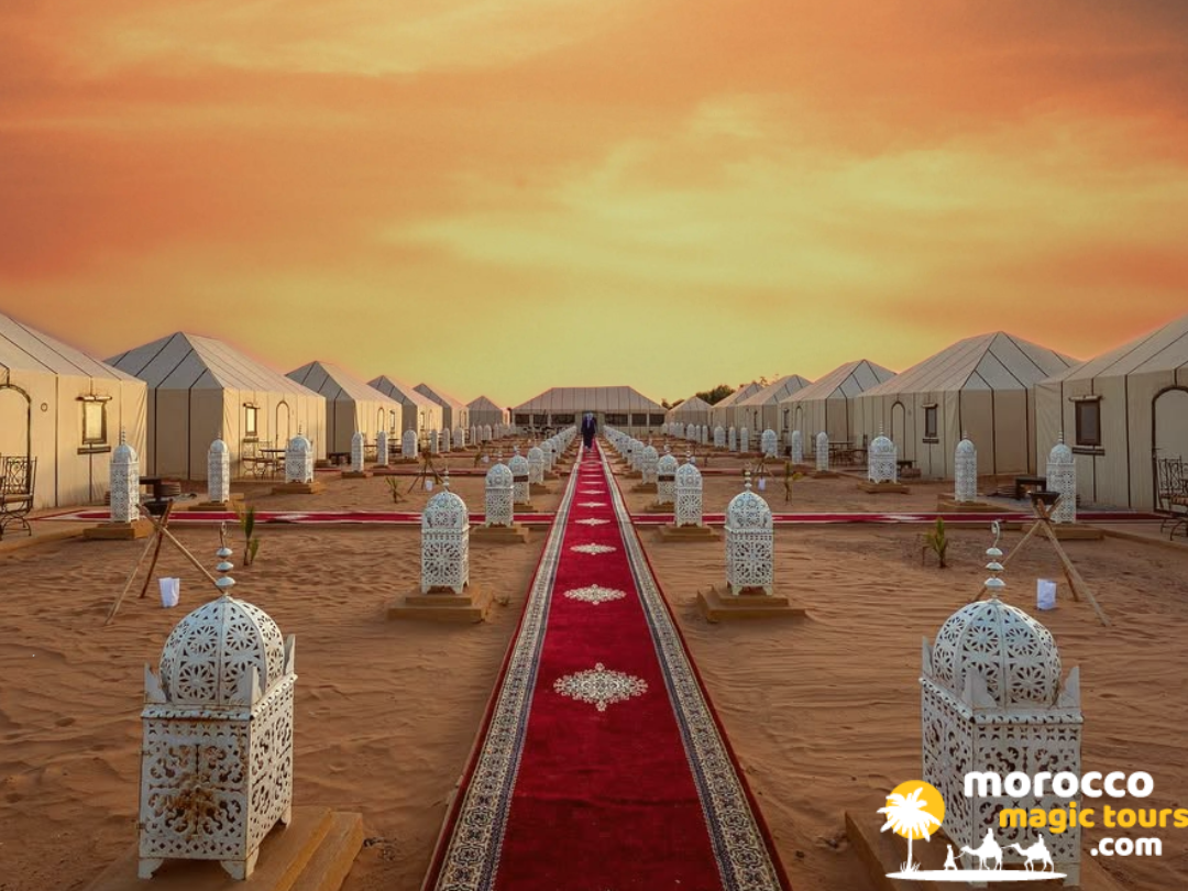 A luxury desert camp aisle lined with white lanterns and a red carpet, perfect for a 10 days desert tour from Casablanca.