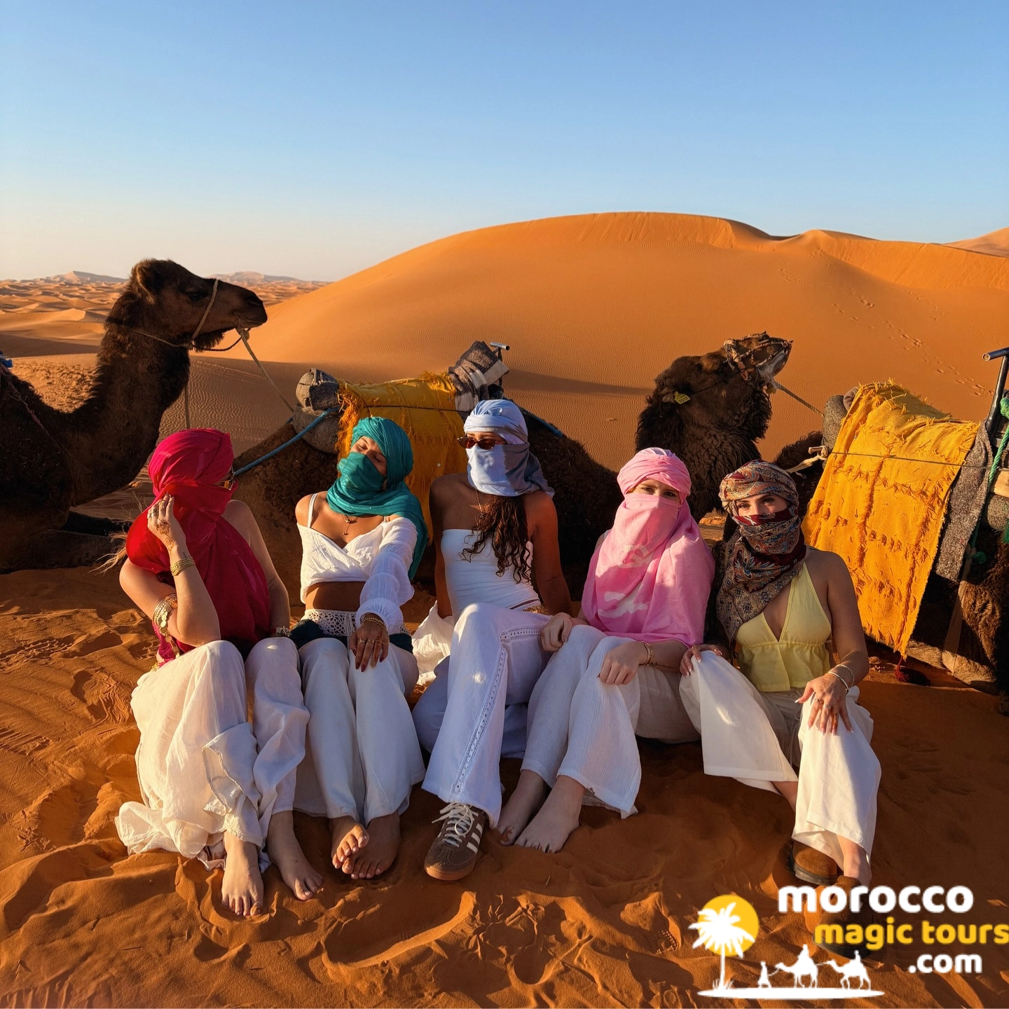 Group of travelers on a camel trek in the dunes, marrakech desert tour 12 days