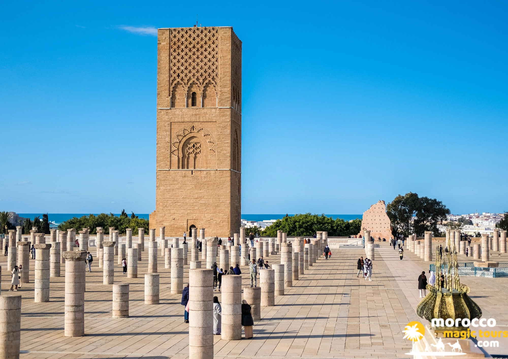 Rows of ancient stone pillars in Rabat with the historic sandstone Hassan Tower rising behind on a Casablanca desert tour.