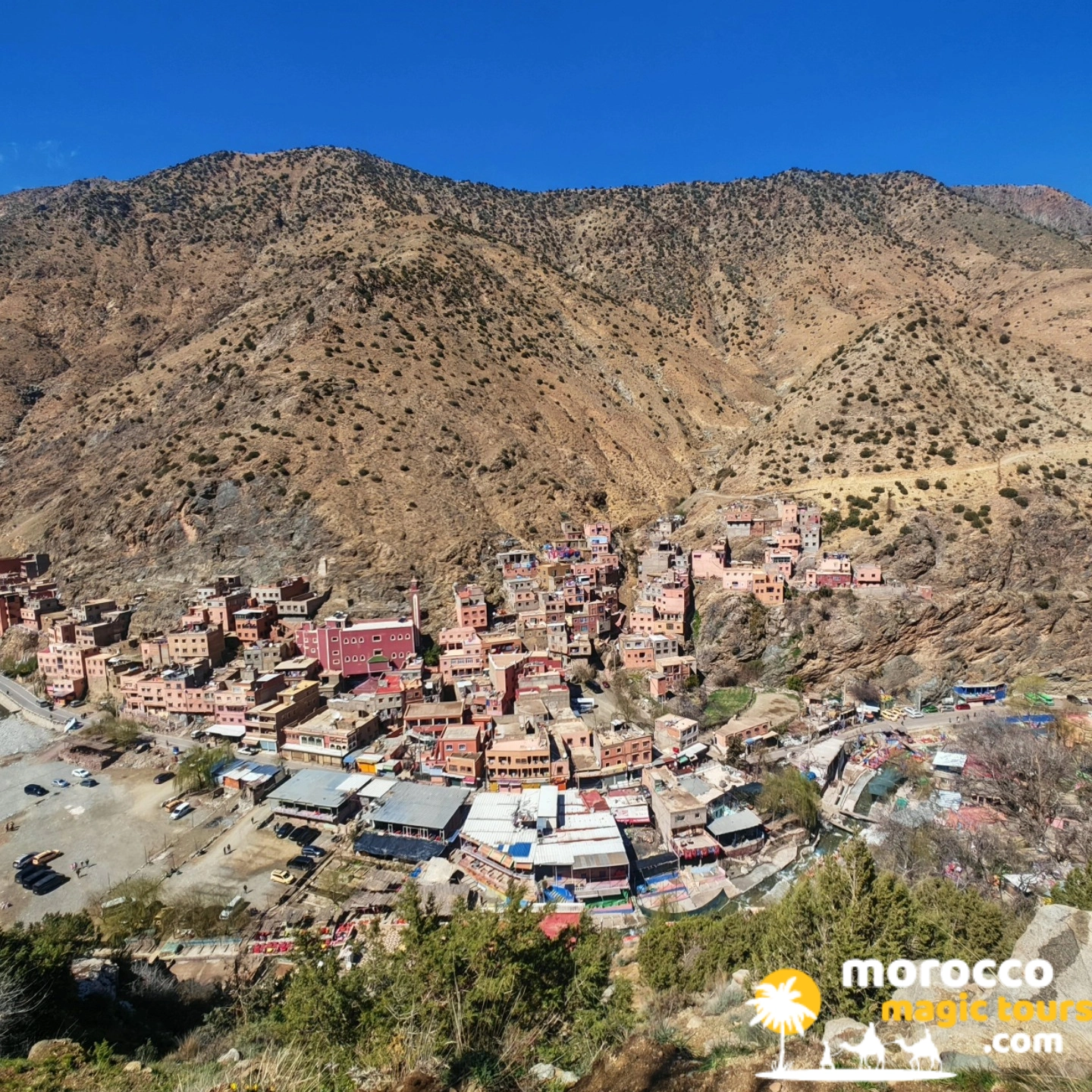 Ourika Valley village with pink Berber houses and mountain backdrop near Marrakech