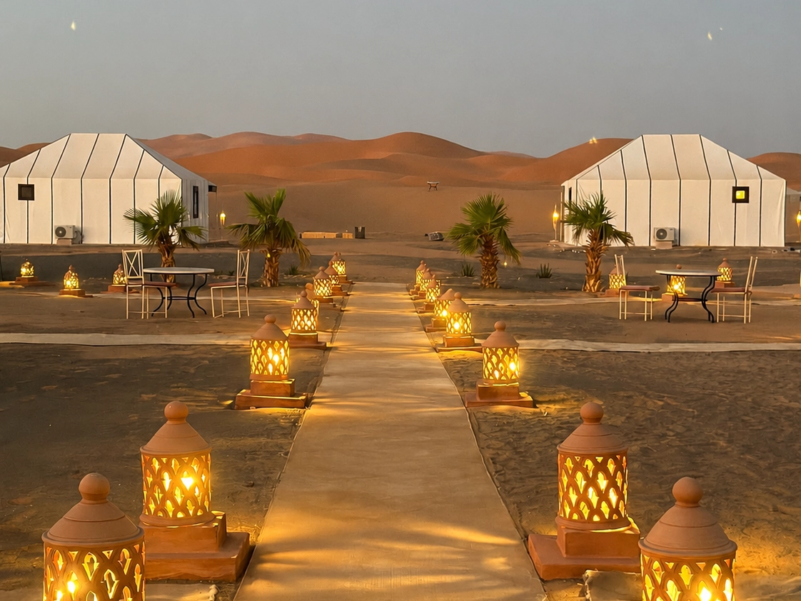 Luxury desert camp near Merzouga with lantern-lit path, included in camel ride Merzouga overnight packages