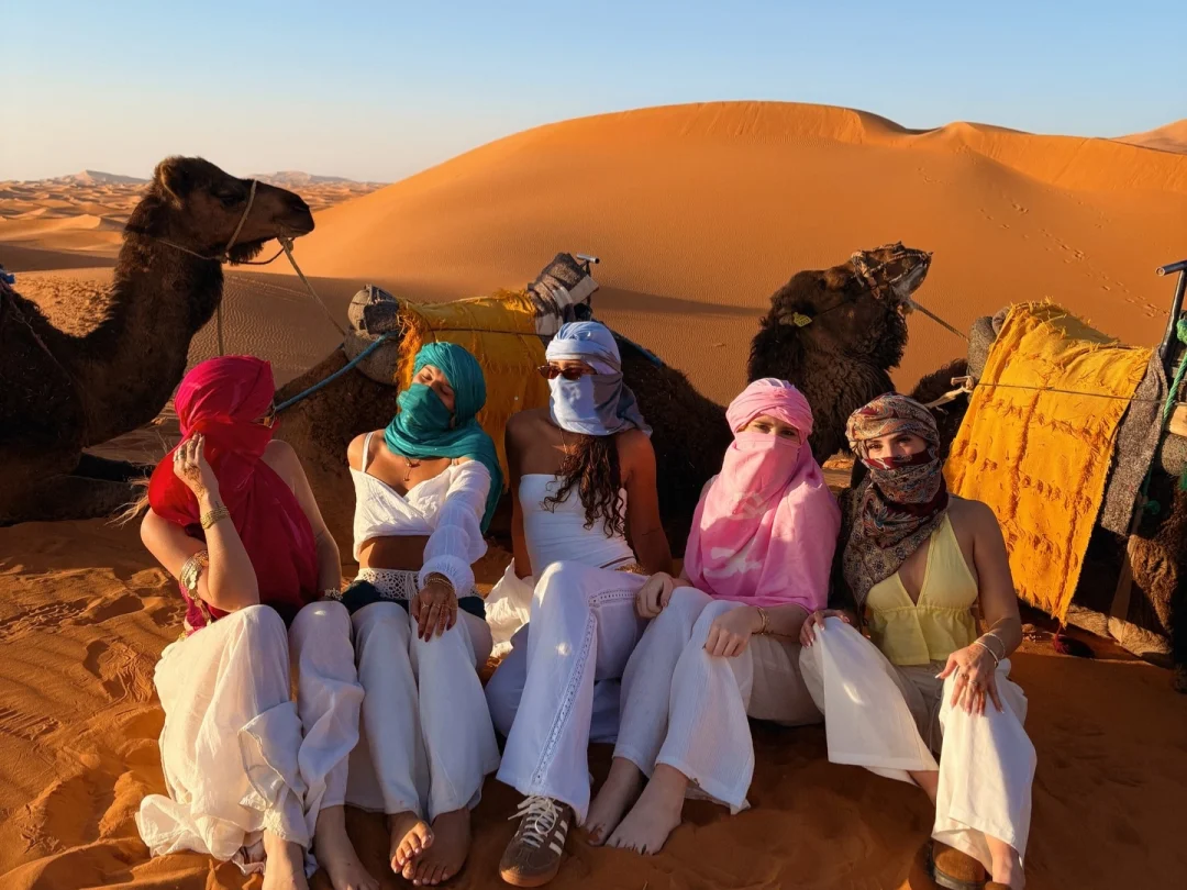 camel-trek-group-dunes Group of travelers on a camel trek in the dunes, marrakech desert tour 12 days